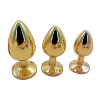 Elevate your play with a luxurious, golden, stainless steel, metal sex toy featuring a stunning jewel in a variety of colors like red, sky blue and pink.