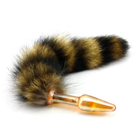 Indulge in play with this fur raccoon sex toy featuring a brown tail and a glass sex toy in black, clear, gold, or green.